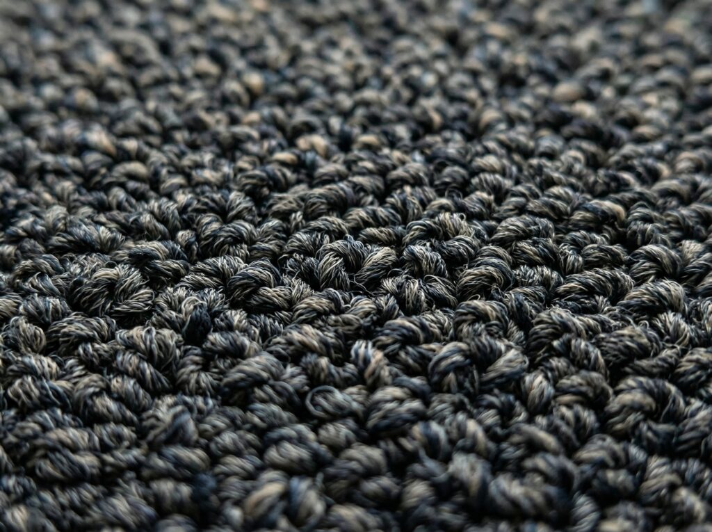 Detalhe de textura de carpete comercial com técnica de tufting bouclê
