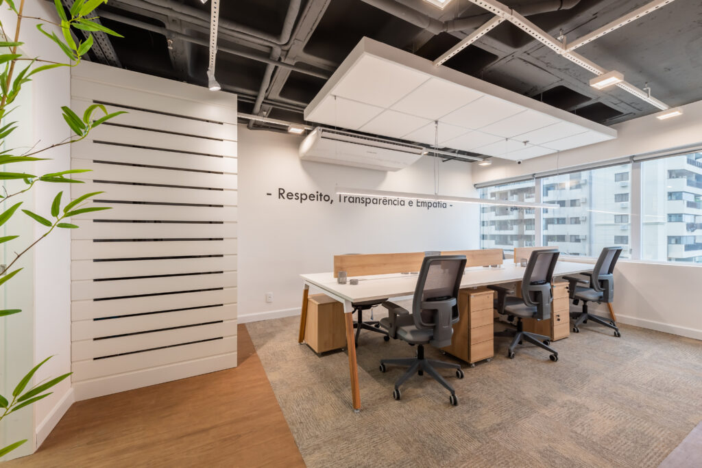 Ambiente corporativo planejado com estações de trabalho, cadeiras ergonômicas, divisórias de vidro, carpete e mobiliário corporativo da Mirage Móveis.